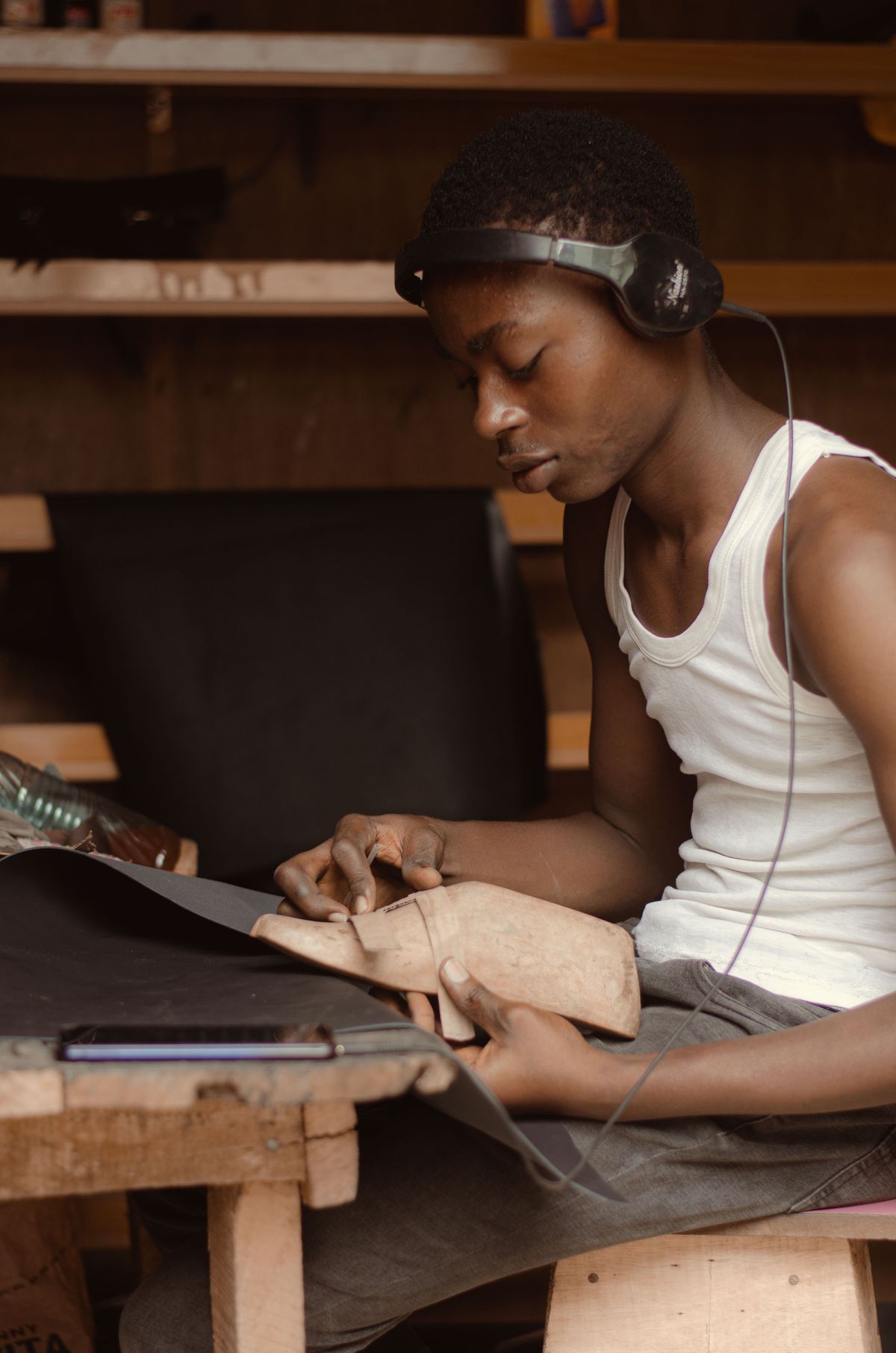 A craftsman concentrating on leatherwork in an Abeokuta workshop