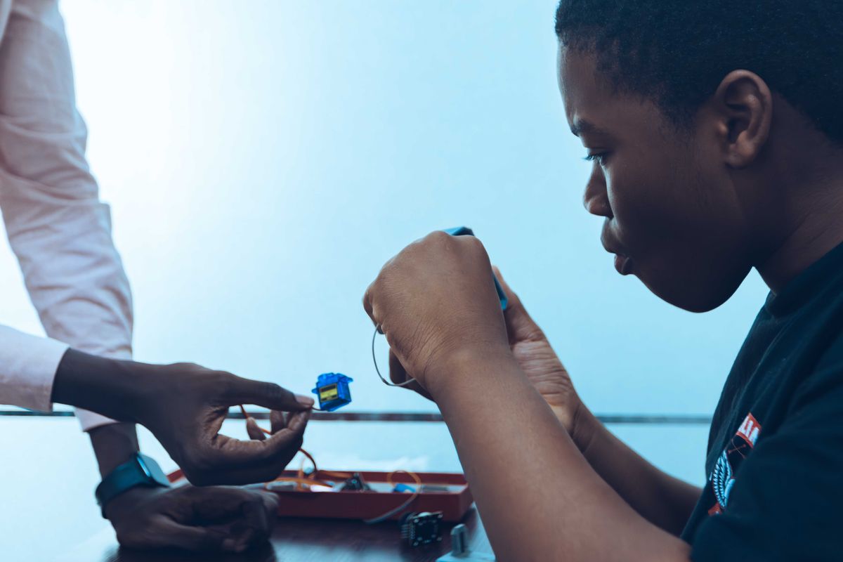 Students connecting electronic components at a technology workshop in Accra