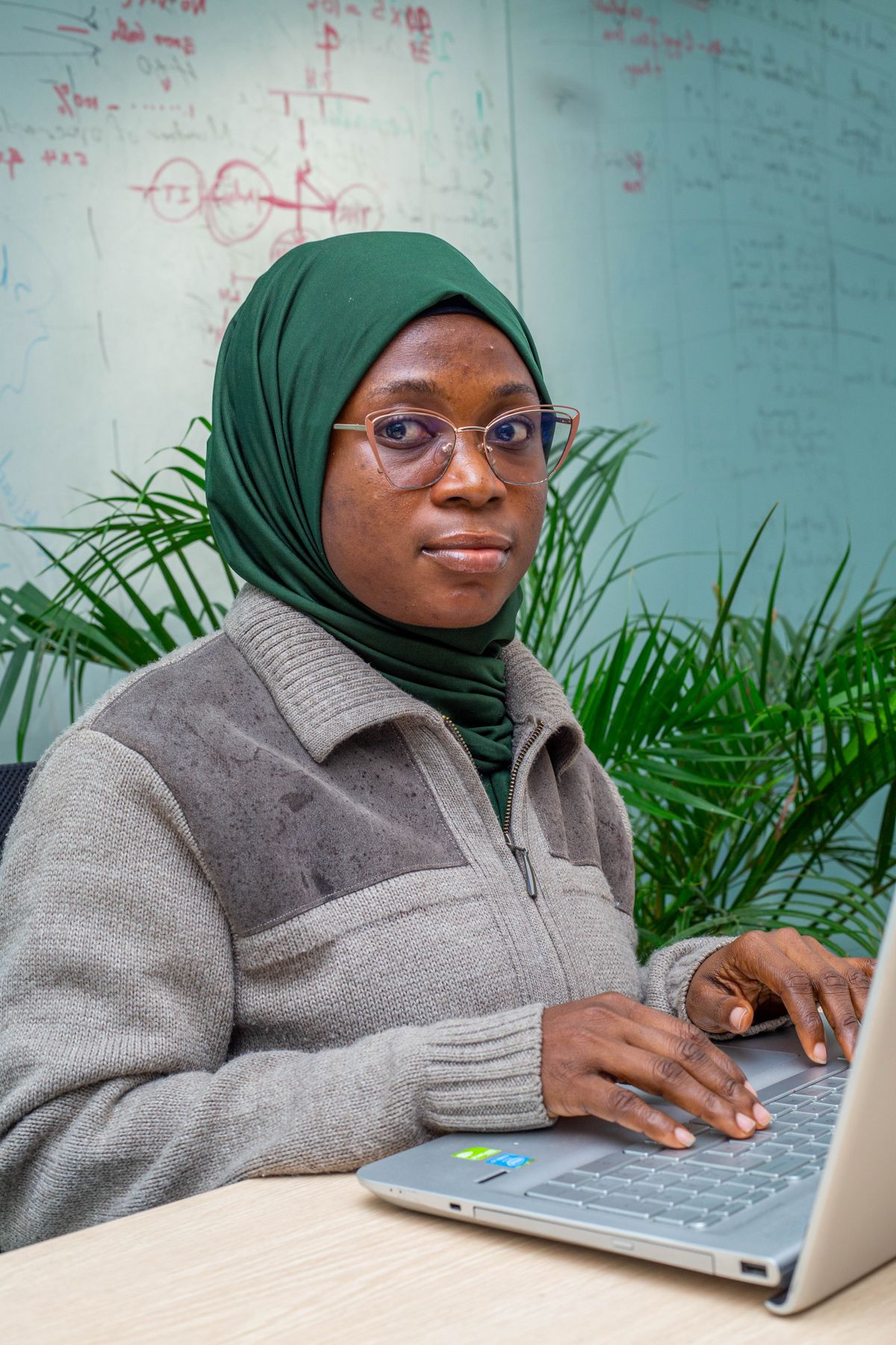 A woman wearing a headscarf working on a laptop in Lagos