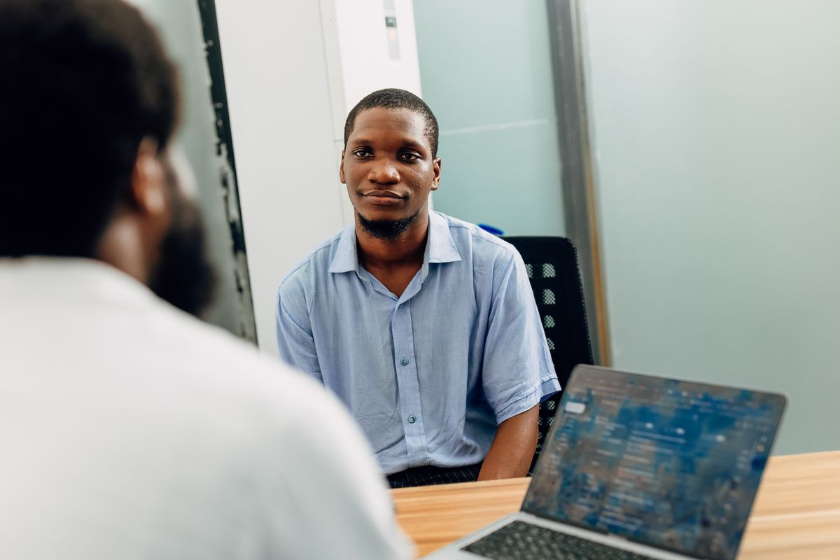 Two professionals in conversation at a Lagos office