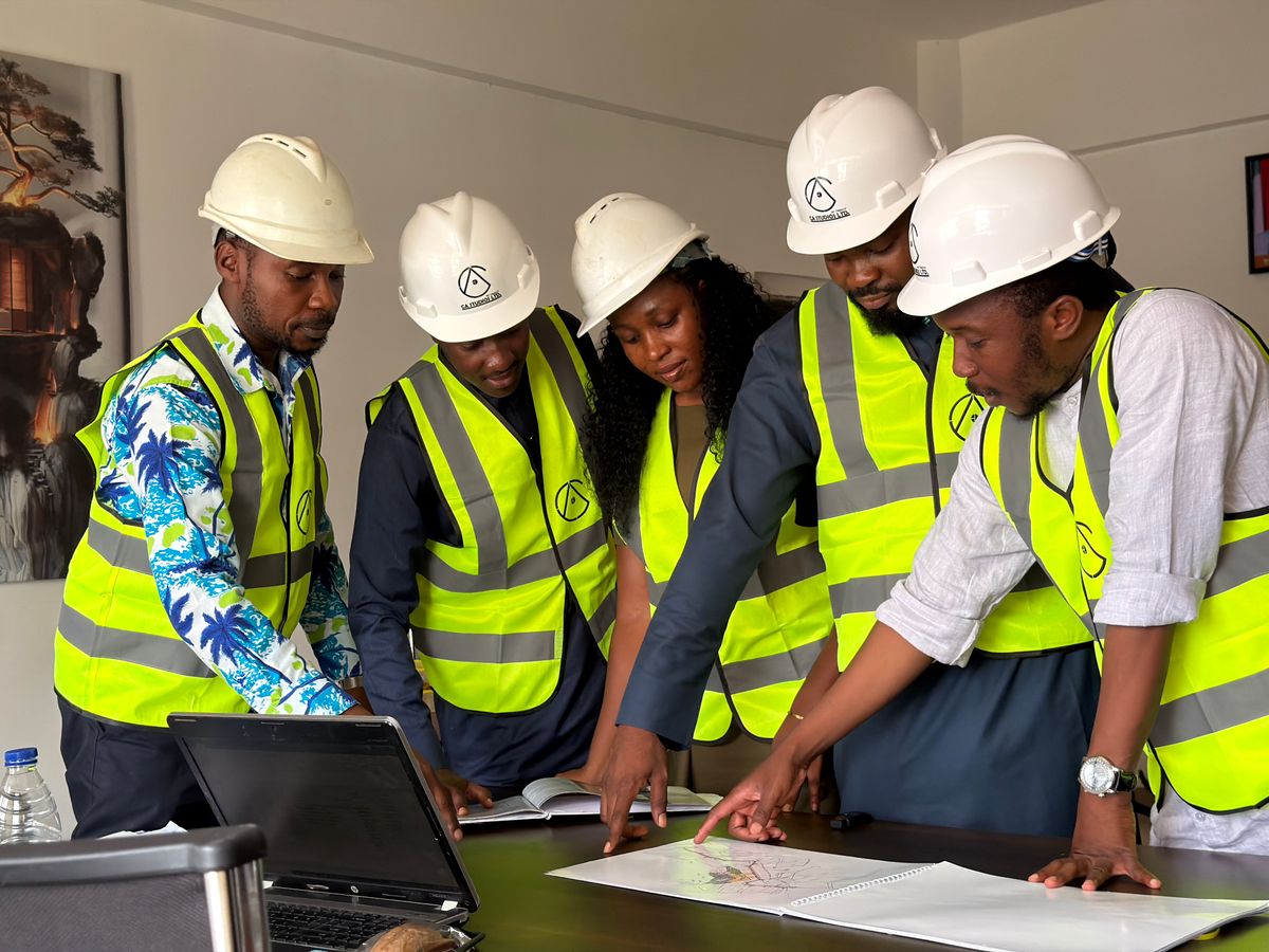 Engineers in safety equipment reviewing plans in Abuja