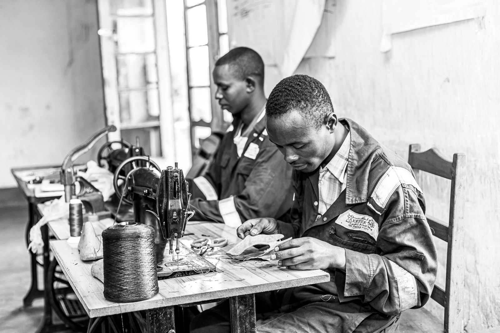 Two tailors concentrating on their work in a workshop