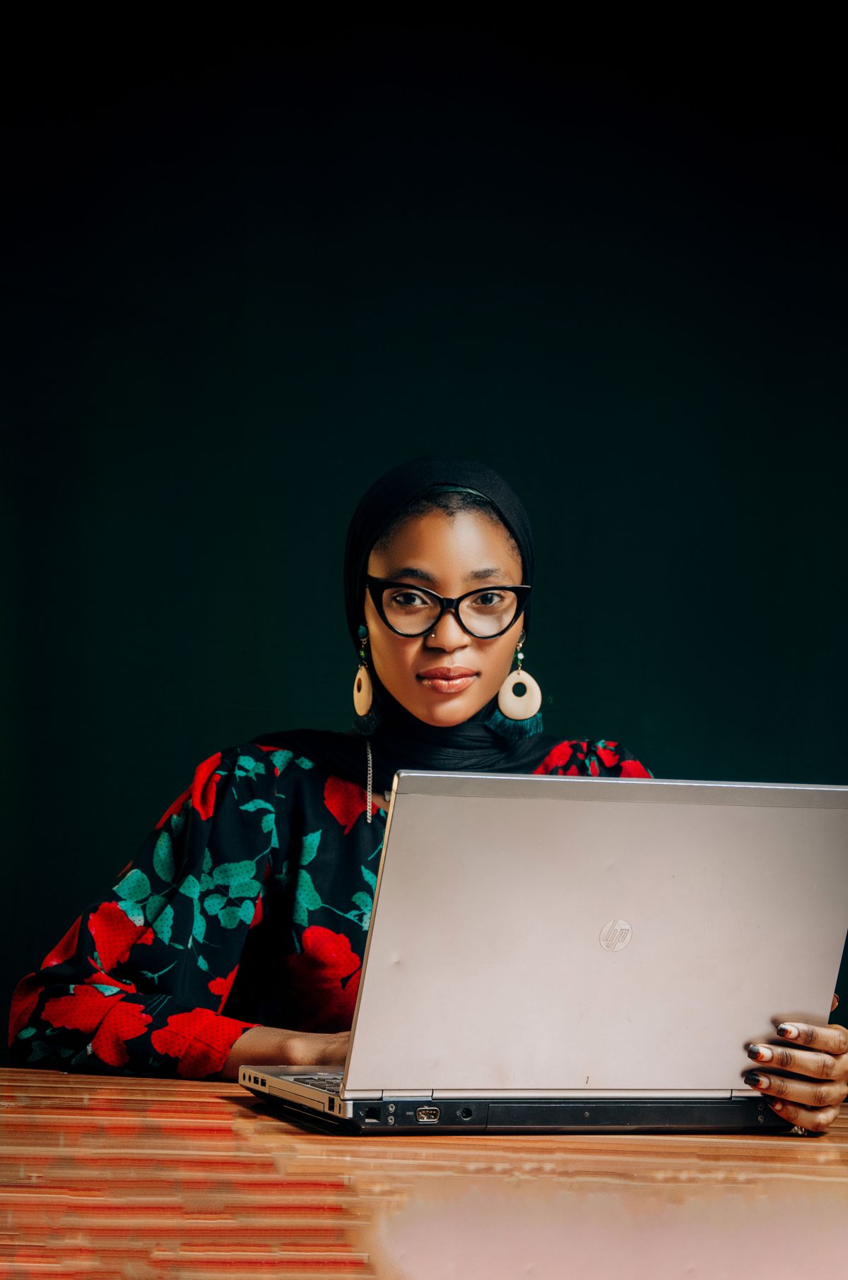 A woman in colourful attire working on a laptop in Nigeria