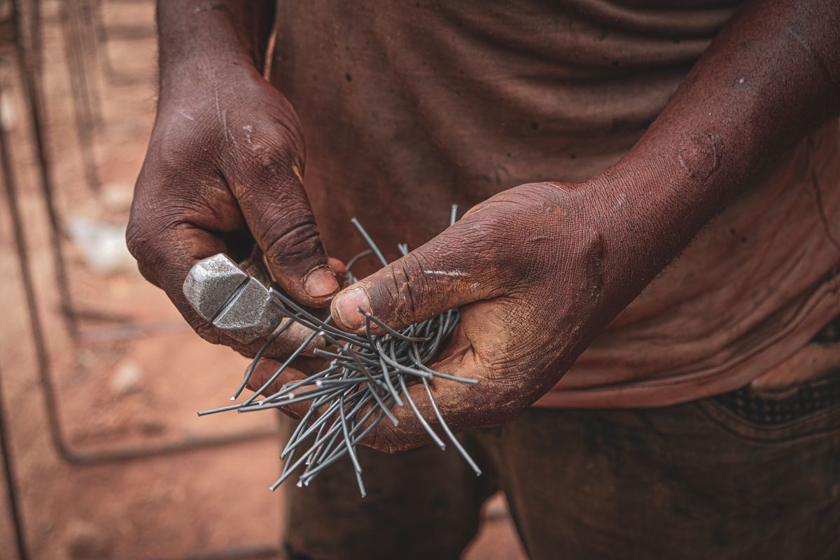Close-up of a craftsman working with hand tools and wire in Ife